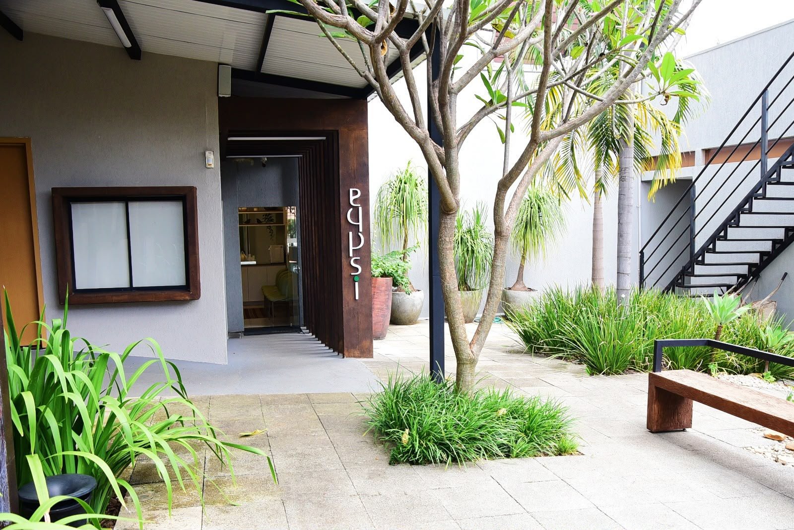 Entrada da clínica Eqpsi, com caminho e jardim externo